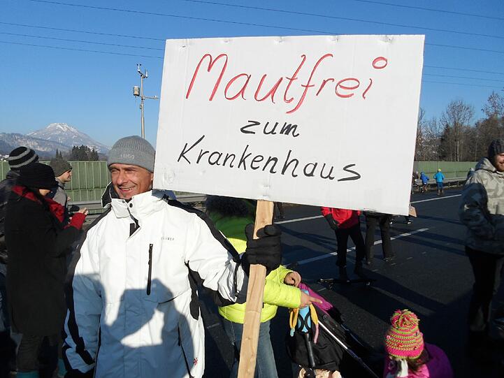 Kunterbunte Demo mitten auf der - gesperrten - Inntal-Autobahn. Der Mann hat ein klares Anliegen.