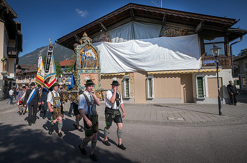 Katholiken ziehen zur Fronleichnamsprozession durch die Gemeinde Garmisch-Partenkichen.