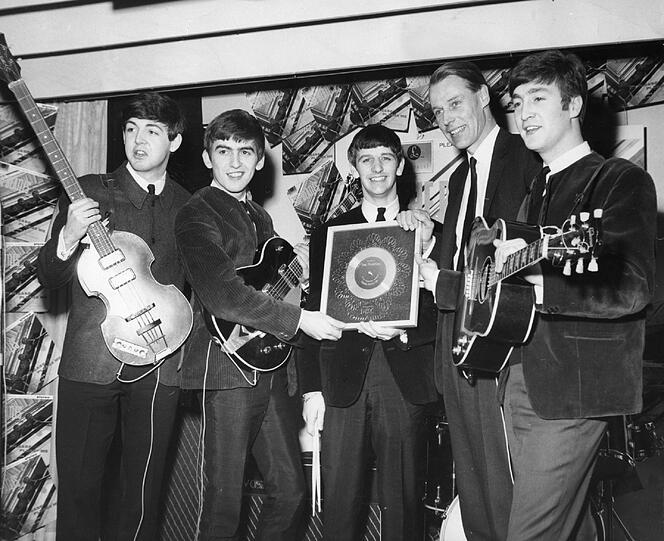George Martin (2.v.r.) feiert mit den Beatles 1963 ihre Durchbruch-Single &bdquo;Please Please Me&ldquo;. V.l.: Paul, George, Ringo, John.
