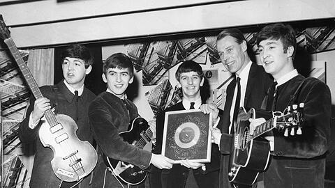 George Martin (2.v.r.) feiert mit den Beatles 1963 ihre Durchbruch-Single &bdquo;Please Please Me&ldquo;. V.l.: Paul, George, Ringo, John.