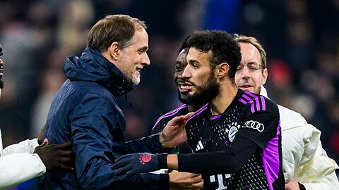 Münchens Trainer Thomas Tuchel (l) klatscht nach dem Spiel mit Münchens Noussair Mazraoui (r) ab.