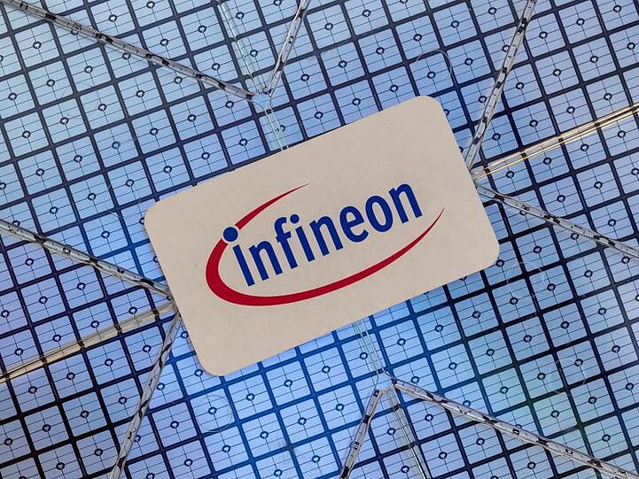 Das Infineon-Logo klebt auf einem Wafer im Showroom des Unternehmens. Foto: Peter Kneffel/dpa/Symbolbild
