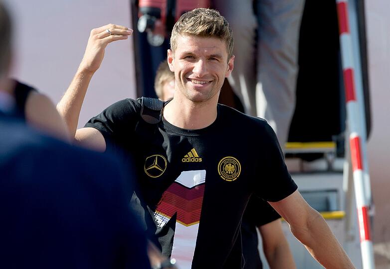 Thomas Müller präsentiert seine Siegerfaust bei der Ankunft am Münchner Flughafen.