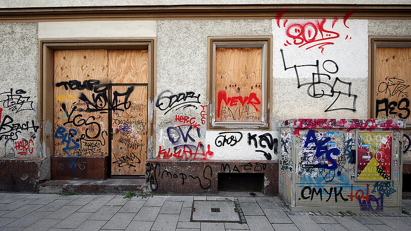 Westendstraße 35: mit Brettern vernagelte Fenster im Erdgeschoss und eine über die Jahre immer mehr vollgeschmierte Fassade.