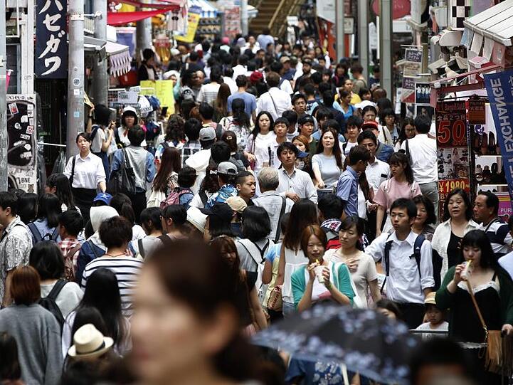 Menschen drängen sich auf einer Straße der japanischen Hauptstadt.