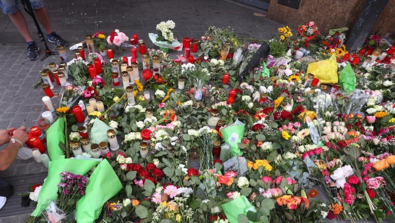 Kerzen und Blumen liegen vor einem geschlossenen und abgesperrten Geschäft in der Innenstadt. Kerzen und Blumen liegen vor einem geschlossenen und abgesperrten Geschäft in der Innenstadt.