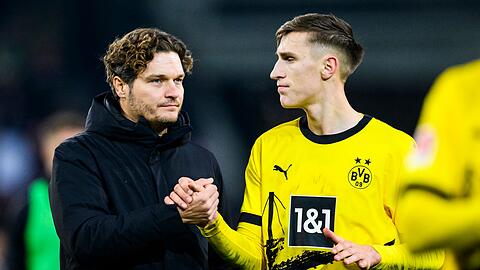 Dortmunds Trainer Edin Terzic (l) klatscht nach dem Spiel mit Dortmunds Nico Schlotterbeck (r) ab.