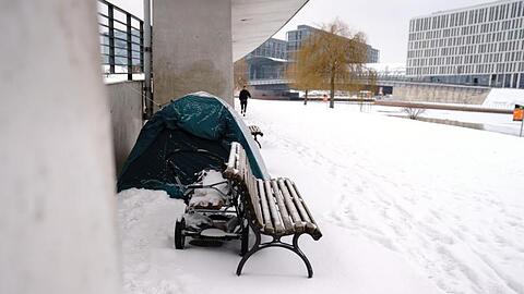 Das Zelt eines Obdachlosen steht bei kalten Temperaturen am Spreeufer im Schnee.