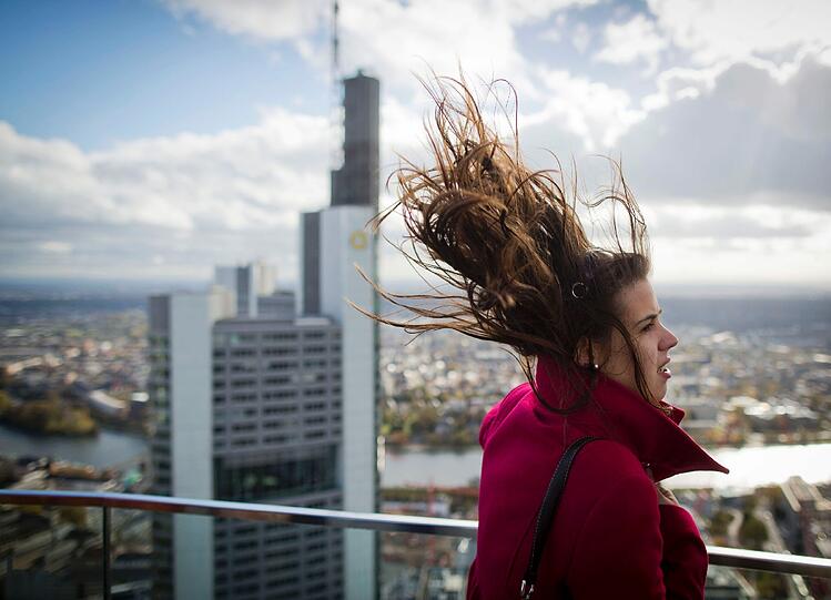 Jana Rechmechido, eine Touristin aus Portugal, steht auf der Aussichtsplattform der Maintowers in Frankfurt am Main. Da oben in 200 Metern ist es ganz schön windig.