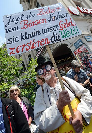 Ein Demonstrant mit Plakat: "Jagt die Börsen Zocker vom Hocker".
