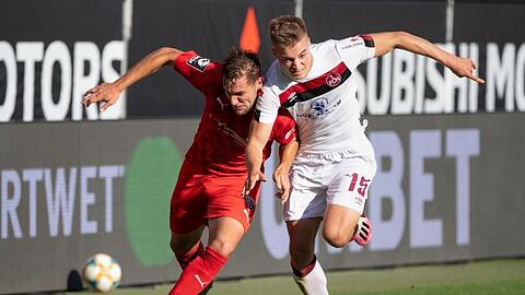 Michael Heinloth von Ingolstadt (l) und Fabian Nürnberger von Nürnberg im Kampf um den Ball.