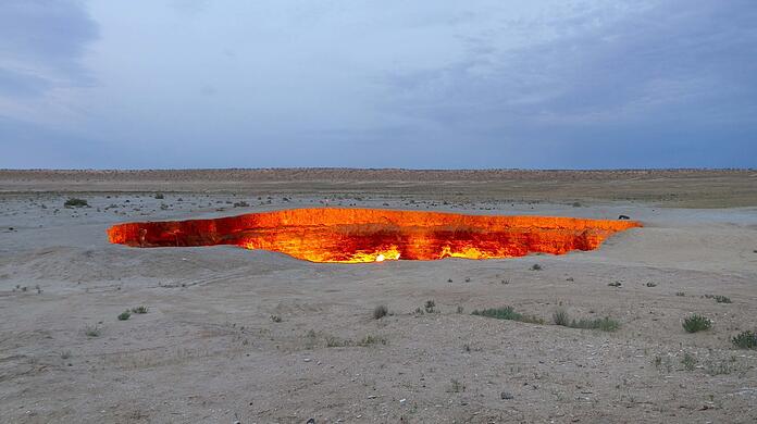 Das "Höllentor" - oder der Gaskrater - von Derweze in Turkmenistan: Laut Überlieferung entdeckten die Sowjets hier 1971 eine gewaltige Kaverne, aus der giftige Gase strömten. Sie zündeten sie an - und das Feuer im Inneren der Erde lodert bis heute.
