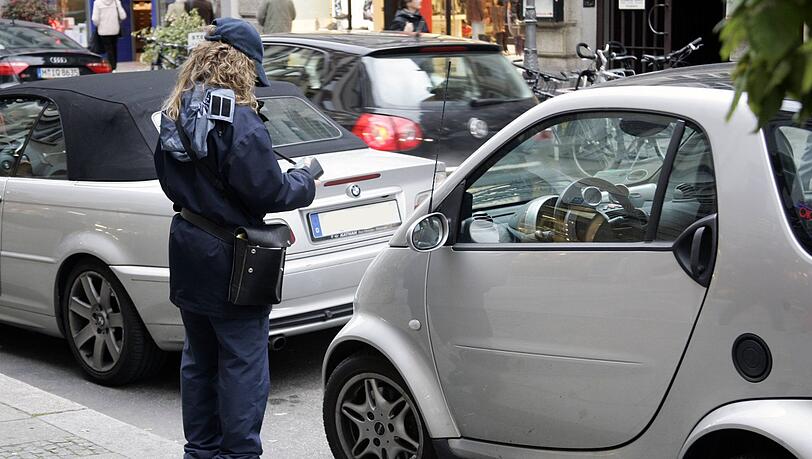 Eine Politesse notiert ein falsch parkendes Auto in München. (Symbolbild) Eine Politesse notiert ein falsch parkendes Auto in München. (Symbolbild)