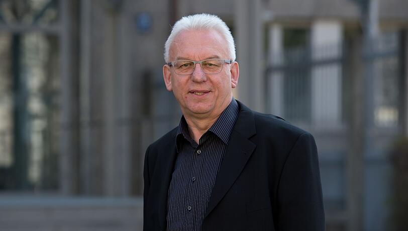Alfred Hettmer steht vor dem Haupteingang des Bayerischen Landeskriminalamts (LKA).