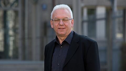 Alfred Hettmer steht vor dem Haupteingang des Bayerischen Landeskriminalamts (LKA).
