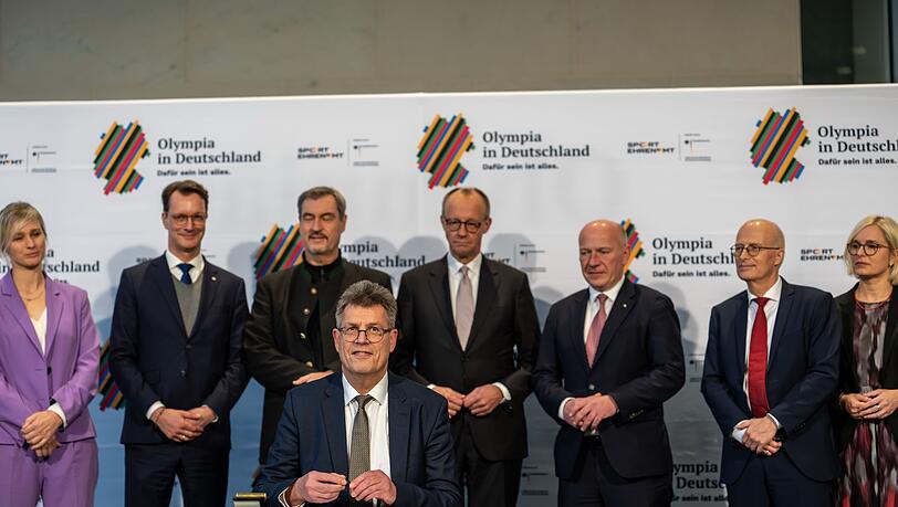 Wer übernimmt bei Olympia? Wüst (2. v. l.) und Söder (3. v. l.) sind in Position. (Archivbild) Wer übernimmt bei Olympia? Wüst (2. v. l.) und Söder (3. v. l.) sind in Position. (Archivbild)