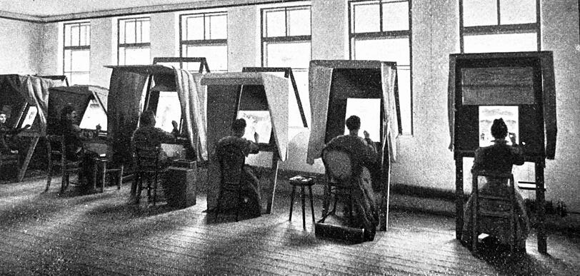 Um 1900: An Pulten mit Spiegeln sitzen die Retuscheure und bearbeiten Negative.