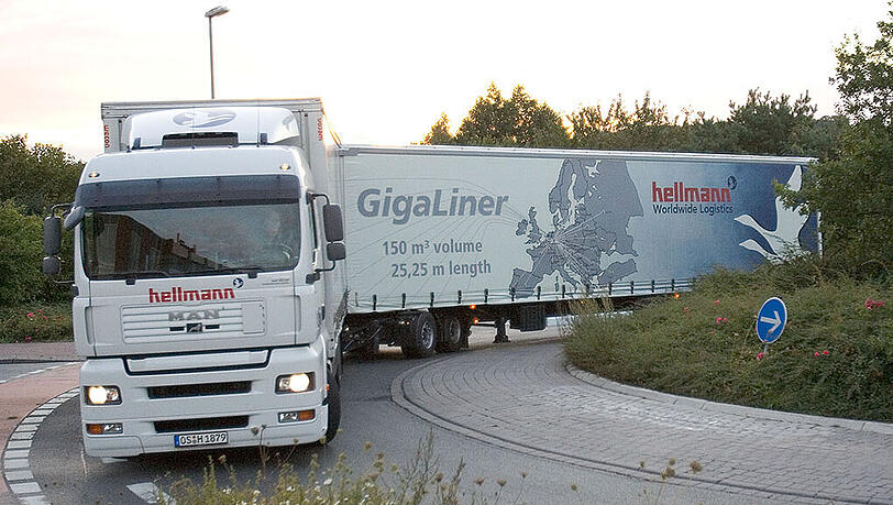 Ein sogenannter "Gigaliner" (Lastkraftwagen-Kombination mit Motorwagen, Dolly und Sattelauflieger mit einer Fahrzeuglänge von 25 Metern und 40 Tonnen Gesamtgewicht) fährt  in einen Kreisverkehr.
