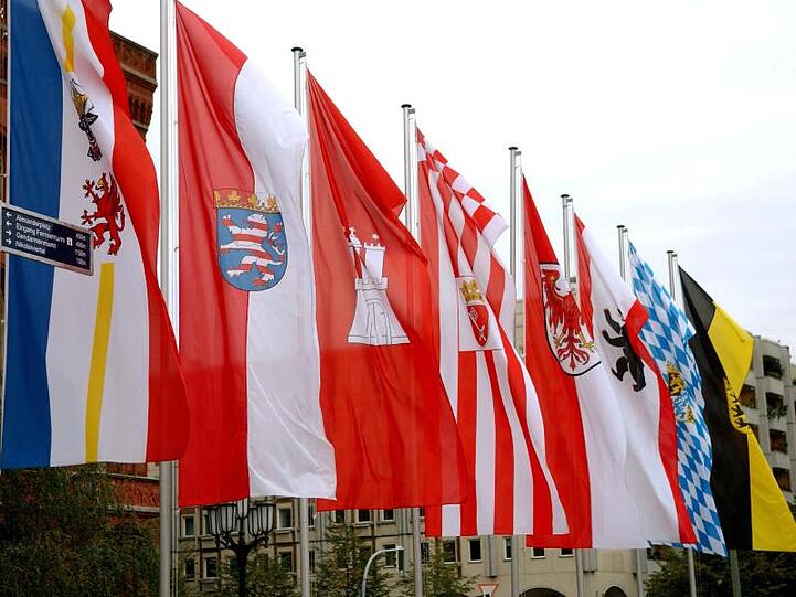 Die Fahnen mehrerer Bundesländer vir dem Berliner Rathaus. Im vergangenen Jahr wurden 11,45 Milliarden Euro zwischen den Ländern umverteilt.