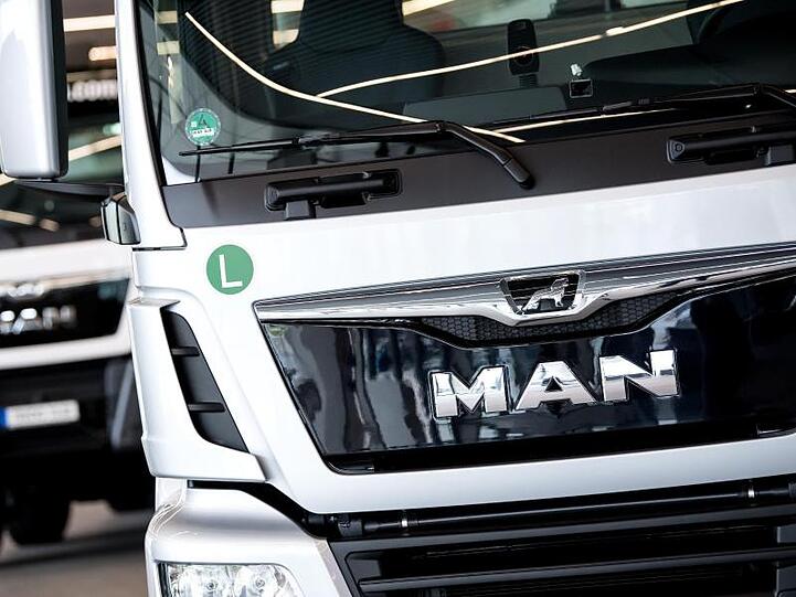 Zwei Lastwagen von MAN stehen in einer Lagerhalle. Foto: Sven Hoppe/dpa/Symbolbild