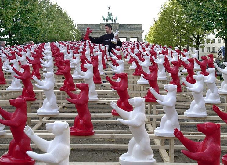 Rund 10 000 rote und wei&szlig;e Plastik-B&auml;ren im Jahr 2000 vor dem Brandenburger Tor in Berlin von einem jungen Mann auf ein Holzger&uuml;st.