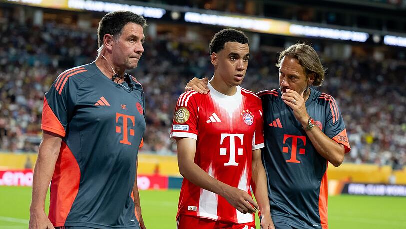 Jamal Musiala musste nur 25 Minuten nach seiner Einwechselung angeschlagen vom Platz, begleitet von Teamarzt (r) und Physiotherapeut.