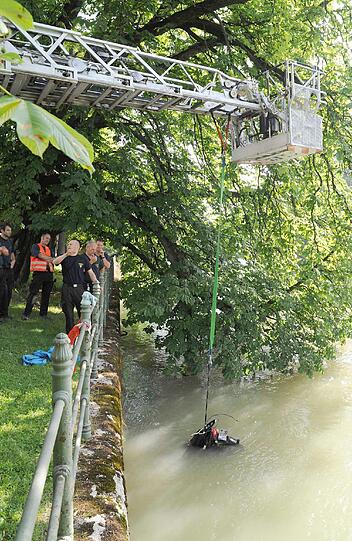 Die Feuerwehr zieht das Moped aus dem Wasser.