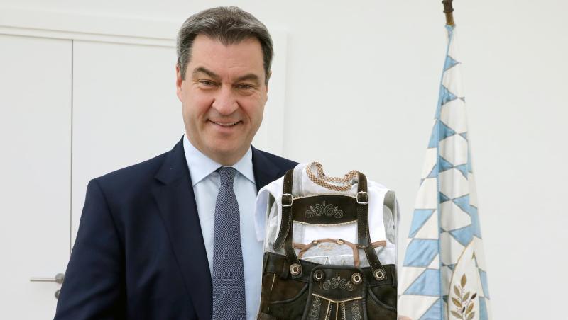 Markus Söder (CSU), Ministerpräsident von Bayern, zeigt eine Lederhose und ein Trachtenhemdchen für Kinder. Foto: Bayerische Staatskanzlei Markus Söder (CSU), Ministerpräsident von Bayern, zeigt eine Lederhose und ein Trachtenhemdchen für Kinder. Foto: Bayerische Staatskanzlei