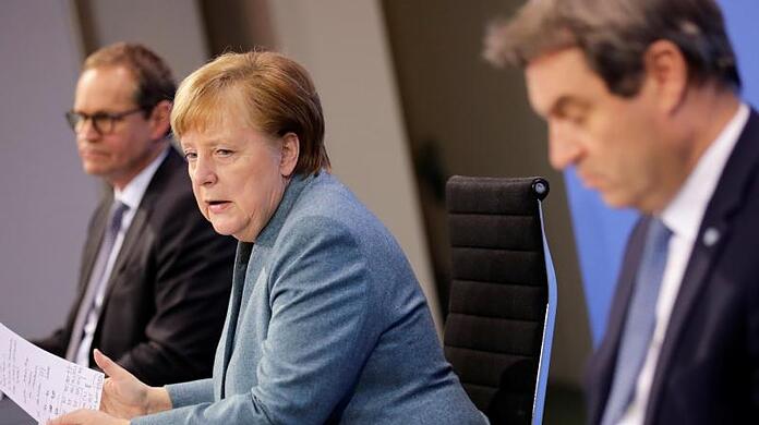 Angela Merkel (CDU, M) spricht zwischen Michael Müller (SPD, l) und Markus Söder (r) auf einer Pressekonferenz.