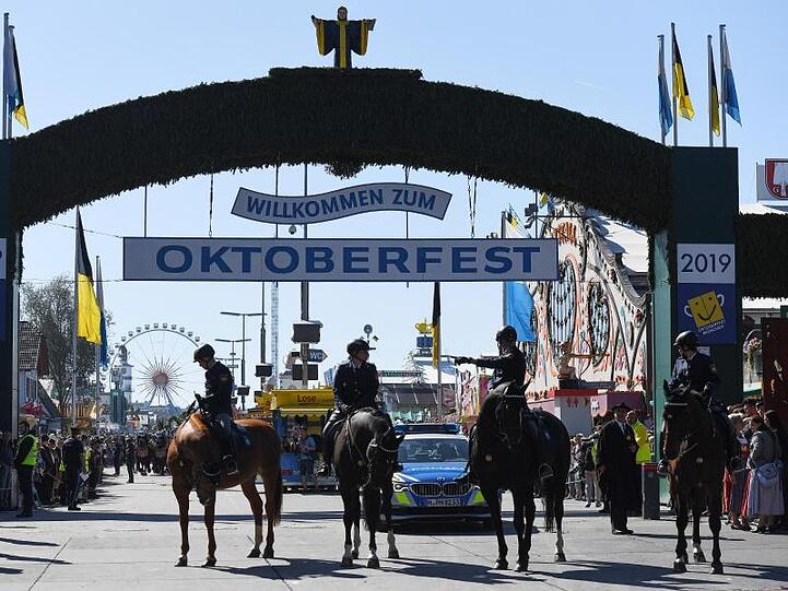 Berittene Polizisten stehen nach dem Einzug der Wiesnwirte zum Oktoberfest vor dem Eingang. Foto: Angelika Warmuth