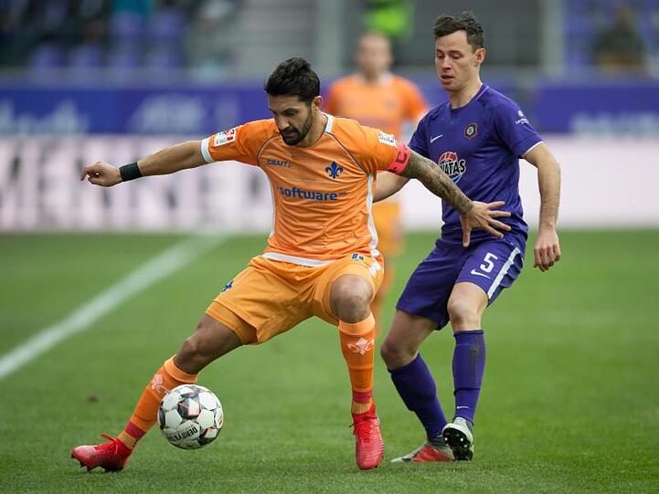 Darmstadt-Kapitän Aytac Sulu (l) schirmt den Ball vor dem Auer Clemens Fandrich ab.