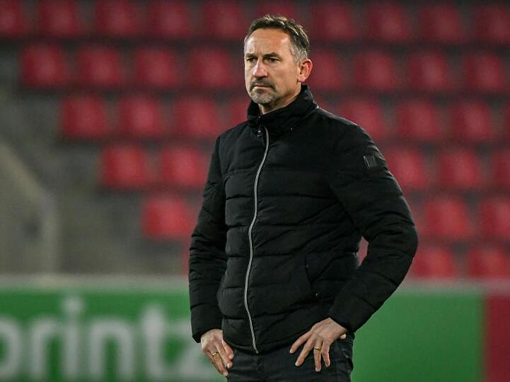 Trainer Achim Beierlorzer von Jahn Regensburg steht vor einem Spiel im Stadion. Foto: Armin Weigel/Archiv