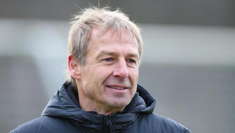 Herthas Trainer Jürgen Klinsmann läuft lächelnd über den Platz. Foto: Andreas Gora/dpa/Archiv Herthas Trainer Jürgen Klinsmann läuft lächelnd über den Platz. Foto: Andreas Gora/dpa/Archiv