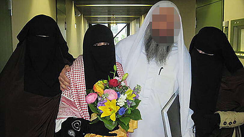 Imam Abu Adam mit seinen drei Ehefrauen. Shaza H. (mit Blumen) bekam eine Bewährungsstrafe wegen falscher Verdächtigung und Freiheitsberaubung. Sie hatte ihn angezeigt, der Imam landete in U-Haft, dann drehte sich der Fall gegen sie. Im Gericht bekundeten 2011 alle Harmonie.