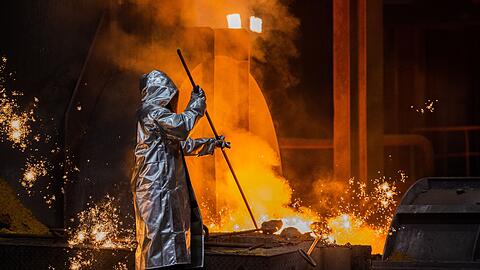 Ein Stahlarbeiter prüft Roheisen am Hochofen 8 auf einem Werksgelände von ThyssenKrupp in Duisburg.