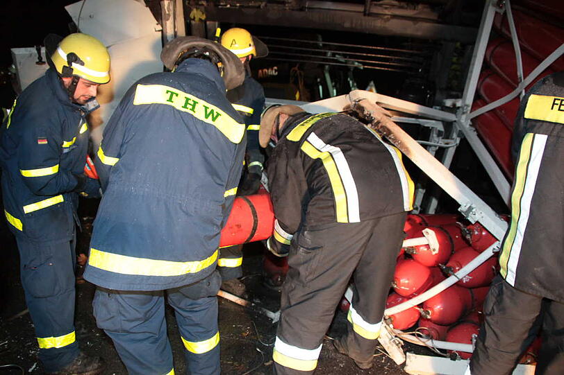 Auf der B 12 kippt ein Laster, der mit Wasserstoff-Flaschen beladen ist. Die enthalten noch Restgas und müssen erst entleert werden. Aus Sicherheitsgründen werden drei Gebäude in der näheren Umgebung evakuiert, drei Personen kommen leicht verletzt ins Krankenhaus.
