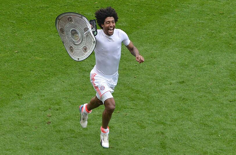Wie feiert der Mann erst, wenn er die richtige Schale hat? Bayerns Abwehrboss Dante dreht mit einer Nachbildung eine Runde im Frankfurter Stadion. Foto: dapd