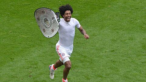 Wie feiert der Mann erst, wenn er die richtige Schale hat? Bayerns Abwehrboss Dante dreht mit einer Nachbildung eine Runde im Frankfurter Stadion. Foto: dapd