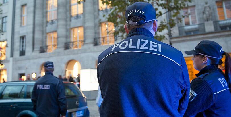 Maskierte überfallen einen Geldboten, als er aus dem Apple-Store kommt - am helllichten Tag, vor den Augen von Passanten.
