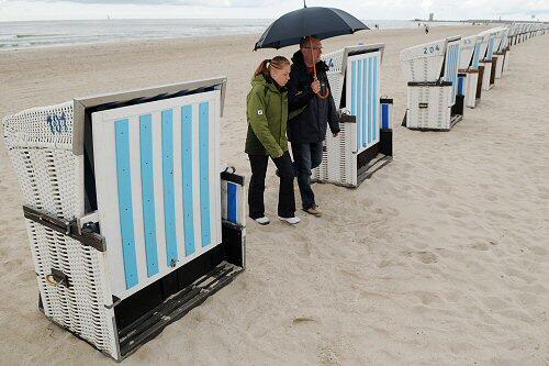 Ein Regenschirm ist derzeit nützlich beim Strandspaziergang