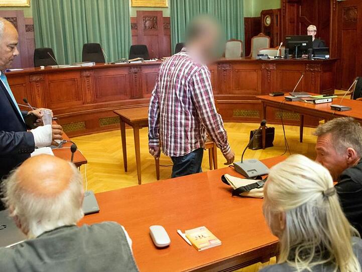 Der wegen Mordes angeklagte Marokkaner (M.) betritt den Gerichtssaal. Im Vordergrund sitzen Andreas Lösche (r.), Bruder der ermordeten Tramperin Sophia Lösche, mit seinen Eltern.