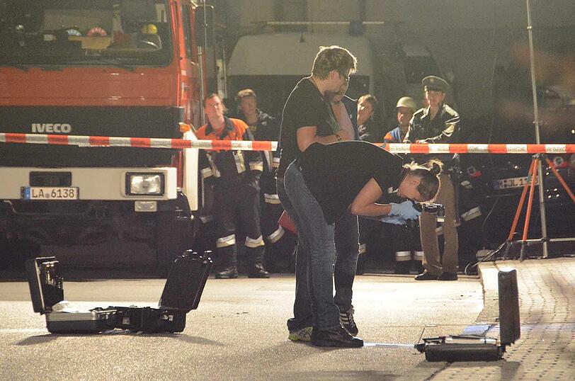 In einem Wohnhaus gegenüber des Veldener Rathauses sind am Montagabend mehrere Schüsse gefallen. Die Einsatzkräfte sichern den Tatort.