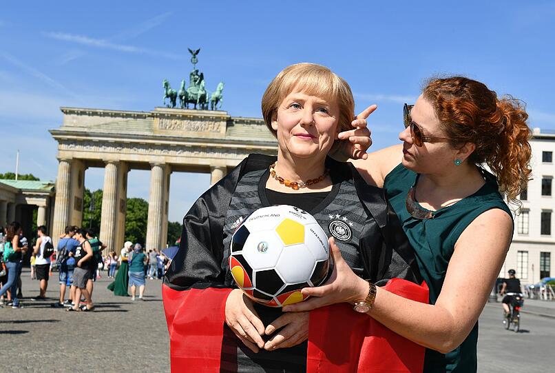 Angela Merkel im Deutschlandtrikot vor dem Brandenburger Tor - leider nur als Wachsfigur. Die Bilder!