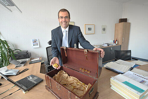 Nürnbergs neuer Kämmerer Harry Riedel (SPD) mit seiner Schatztruhe, die ihm Mitarbeiter geschenkt haben. Sie ist mit Schoko-Talern gefüllt &ndash; als Nervennahrung für harte Sparrunden.