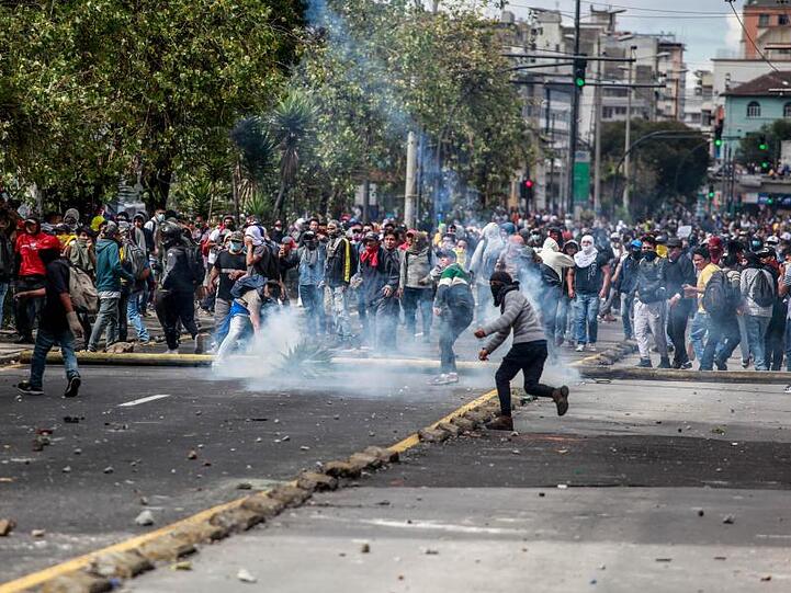 Demonstranten werfen in Quito Steine auf Sicherheitskräfte. .