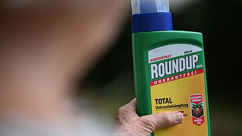 Eine Frau h&auml;lt eine alte Packung des Unkrautvernichters Glyphosat in den H&auml;nden.