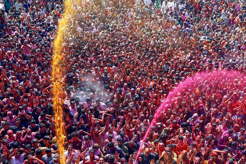 Beim Holy-Festival vor dem Kalupur Swaminarayan Tempel im indischen Ahmedabad gehen ganze Farbsalven über der Menge nieder. Beim Holy-Festival vor dem Kalupur Swaminarayan Tempel im indischen Ahmedabad gehen ganze Farbsalven über der Menge nieder.