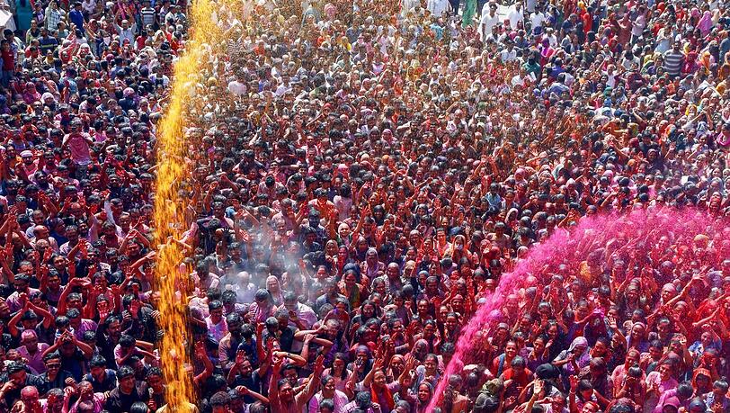 Beim Holy-Festival vor dem Kalupur Swaminarayan Tempel im indischen Ahmedabad gehen ganze Farbsalven über der Menge nieder. Beim Holy-Festival vor dem Kalupur Swaminarayan Tempel im indischen Ahmedabad gehen ganze Farbsalven über der Menge nieder.