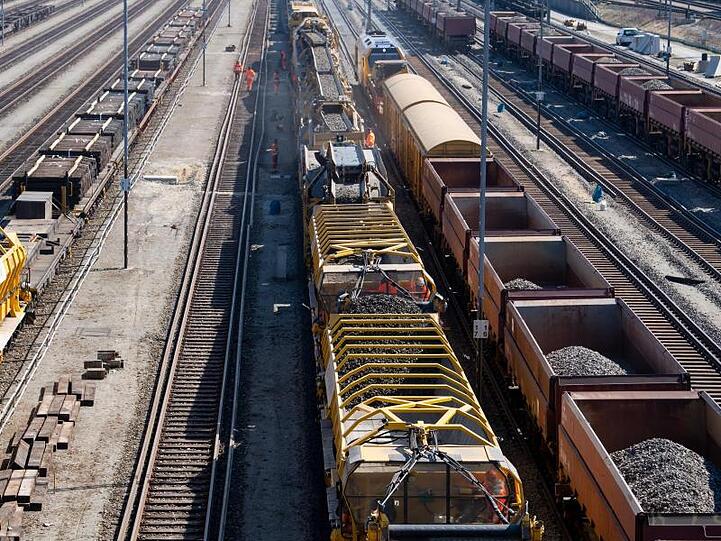 Güterzüge und ein Zug für die Untergrundsanierung von Bahnstrecken stehen auf den Gleisen am Rangierbahnhof München-Nord.