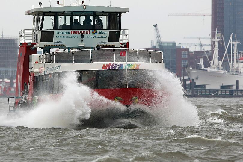 Eine Hafenfähre ist im Hamburger Hafen auf der aufgewühlten Elbe unterwegs